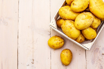Fresh raw potatoes in wooden box