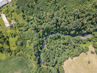 aerial drone view of small river serpentine in forest