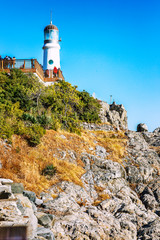 Fototapeta na wymiar Lighthouse on the rocky shore. Clear sunny day. Vertical. Beautiful landscape.