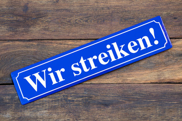 Wir streiken! Schild blau auf Holz