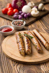 Grilled sausages with sauce ketchup on a wooden table