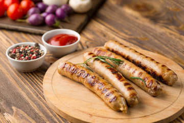 Grilled sausages with sauce ketchup on a wooden table