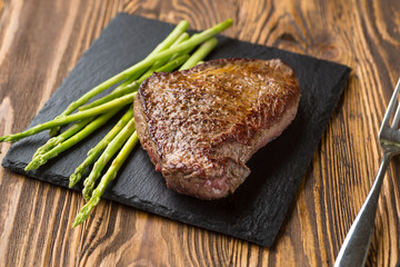 Meat table : grilled beef fillet with asparagus on wooden table