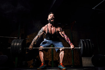 Muscular fitness man doing deadlift of a barbell in modern fitness center. Functional training....