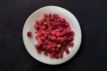 fresh raw raspberries in the plate, top view