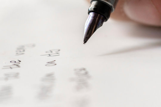 macro shot of fountain pen writing on white surface
