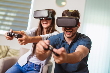 Young happy couple playing video games virtual reality glasses. Couple having fun with new trends technology. © Mediteraneo