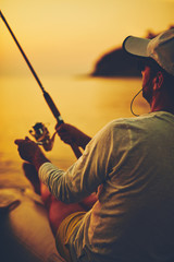 Silhouette of a fisherman fishing in sunset time on the open sea.