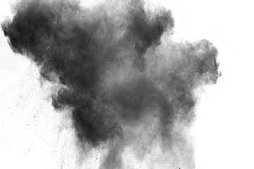 Black powder explosion on white background. Abstract black dust particles splash on white...