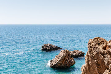 Fototapeta na wymiar Beautiful seascape. Seascape on the background of the wild rocky coast. Wild beach, azure water and rocks. Luxury summer adventure, Mediterranean sea, Turkey. Postcard view