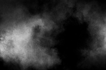 White powder explosion on black background. Abstract white dust texture fly on the air.