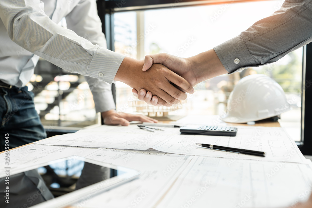 Poster architect and engineer construction workers shaking hands while working for teamwork and cooperation
