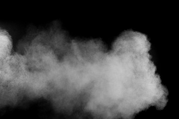 Freeze motion explosion of white powder on a black background.Stopping the movement of white dust on dark background.