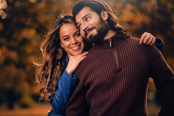 Couple in autumn season colored park enjoying outdoors.