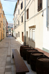 Traditional barrels set as tables on the narrow street of town Pag, island Pag, Croatia.