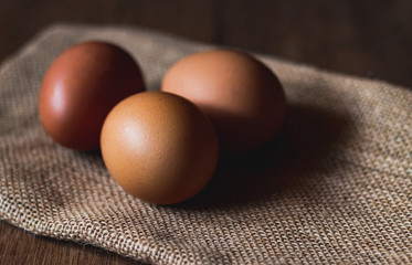 Three eggs on sackcloth and wooden table