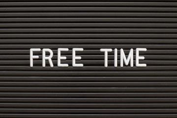 Black color felt letter board with white alphabet in word free time background