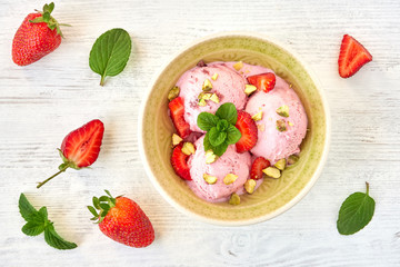 Strawberry ice cream , frozen yogurt with fresh strawberries and mint leaves. Top view