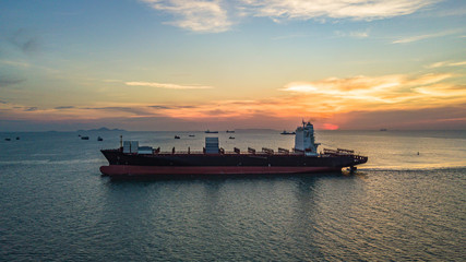 Container ship at sunset, Logistics and transportation of international container ship in the sea.