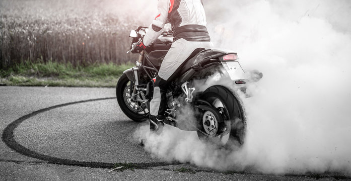 wilder Motorradfahrer lässt die Reifen bei einem Burnout durchdrehen und macht einen Donut