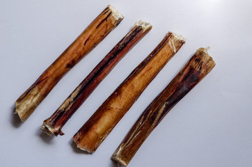Dried Bull pizzle. Bully sticks on light gray background. Shooting from above. Macro.