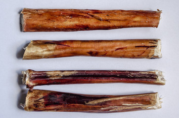 Four chew bully sticks. Dried beef pizzle for pets. Horizontal layout option. White background....