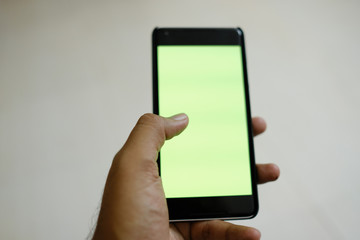 Man hand holding the black smartphone   green screen 