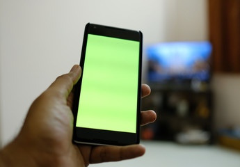 Man hand holding the black smartphone   green screen 