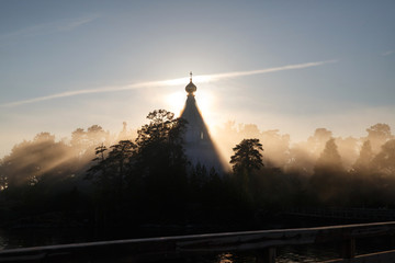 Morning foggy landscape with a silhouette of the church in the sun's rays, Valaam, Karelia, Russia.