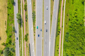 Aerial view of green summer forest with a road.