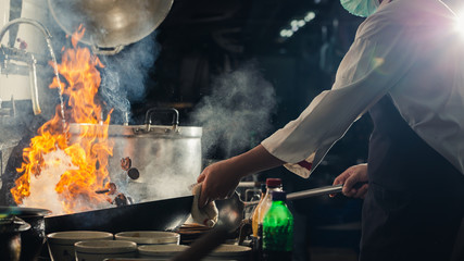 Chef stir fry in wok - obrazy, fototapety, plakaty
