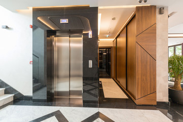 Interior of a shiny marble hotel corridor with elevator