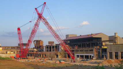 Huge red cranes at construction site - obrazy, fototapety, plakaty
