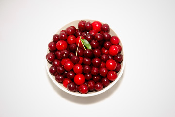 white plate with red cherry on white background