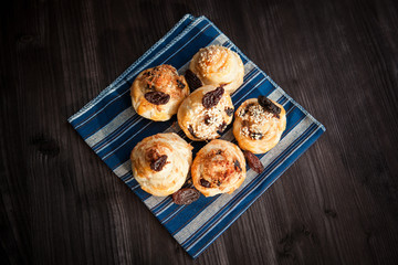  puff buns with raisins on a blue background