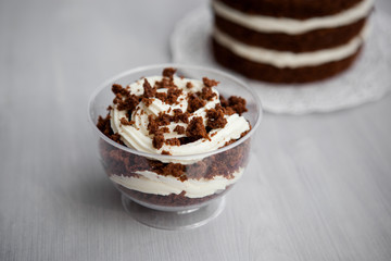 portioned chocolate cake with white cream in a cup