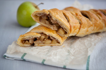 strudel with apple and cinnamon on a light towel, light background