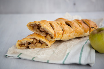strudel with apple and cinnamon on a light towel, light background