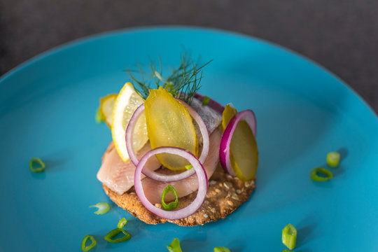 Maatjes Herring on Knackebrod (crisp bread) with Red Onion, Pickels, Lemon and Dill
