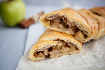 strudel with apple and cinnamon on a light towel, light background