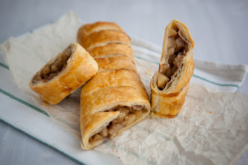 strudel with apple and cinnamon on a light towel, light background