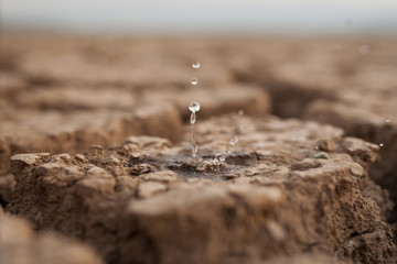 Water drop to dry cracked land metaphor lack of rain, water crisis, Climate change and...