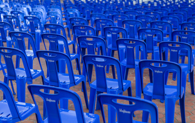 Long blue plastic chairs arranged in long rows