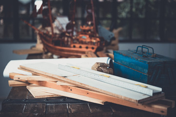 Background image of woodworking workshop, carpenters work table with different tools and wood cutting stand, vintage filter image