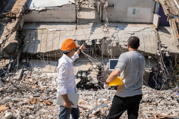 Demolition control supervisor and foreman discussing on demolish building.