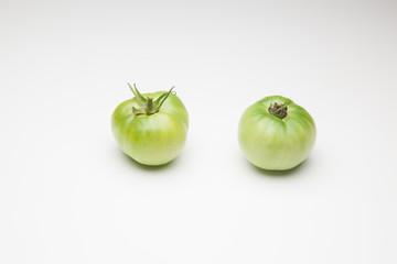 Tomates verdes sobre fondo blanco