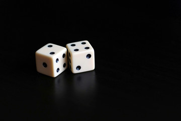 Two dice in a black background.