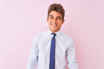 Young handsome businessman wearing shirt and tie standing over isolated pink background winking looking at the camera with sexy expression, cheerful and happy face.