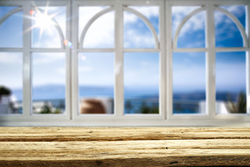 Fototapeta na wymiar Wooden table background and white window frame and beautiful blurred ocean view