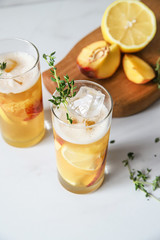 Fototapeta premium Fresh peach lemonade on light marble background. Top view